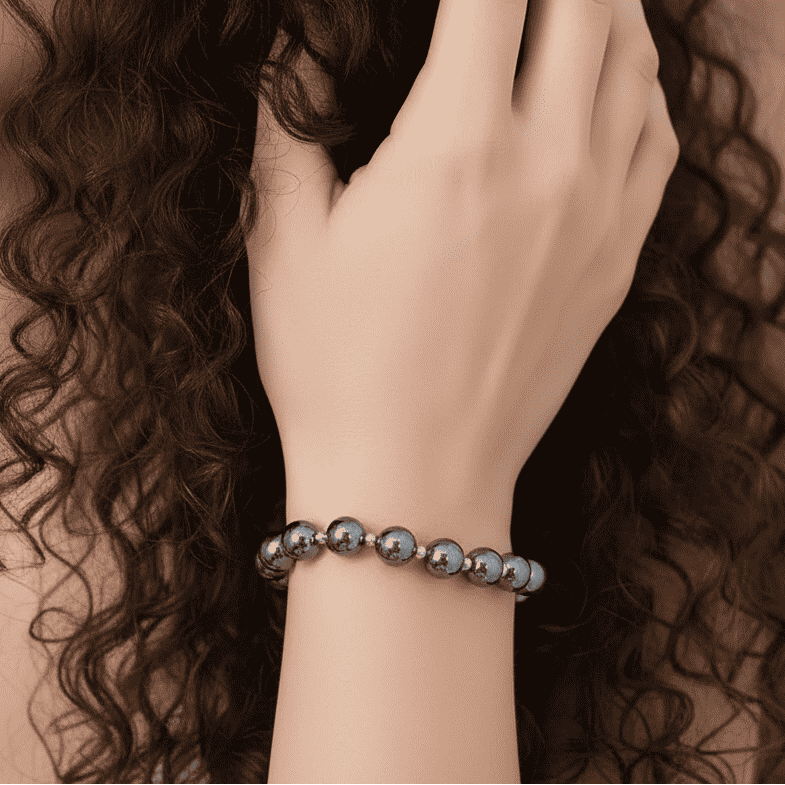 Bracelet en perles d’hématite porté au poignet, billes noir argenté brillantes